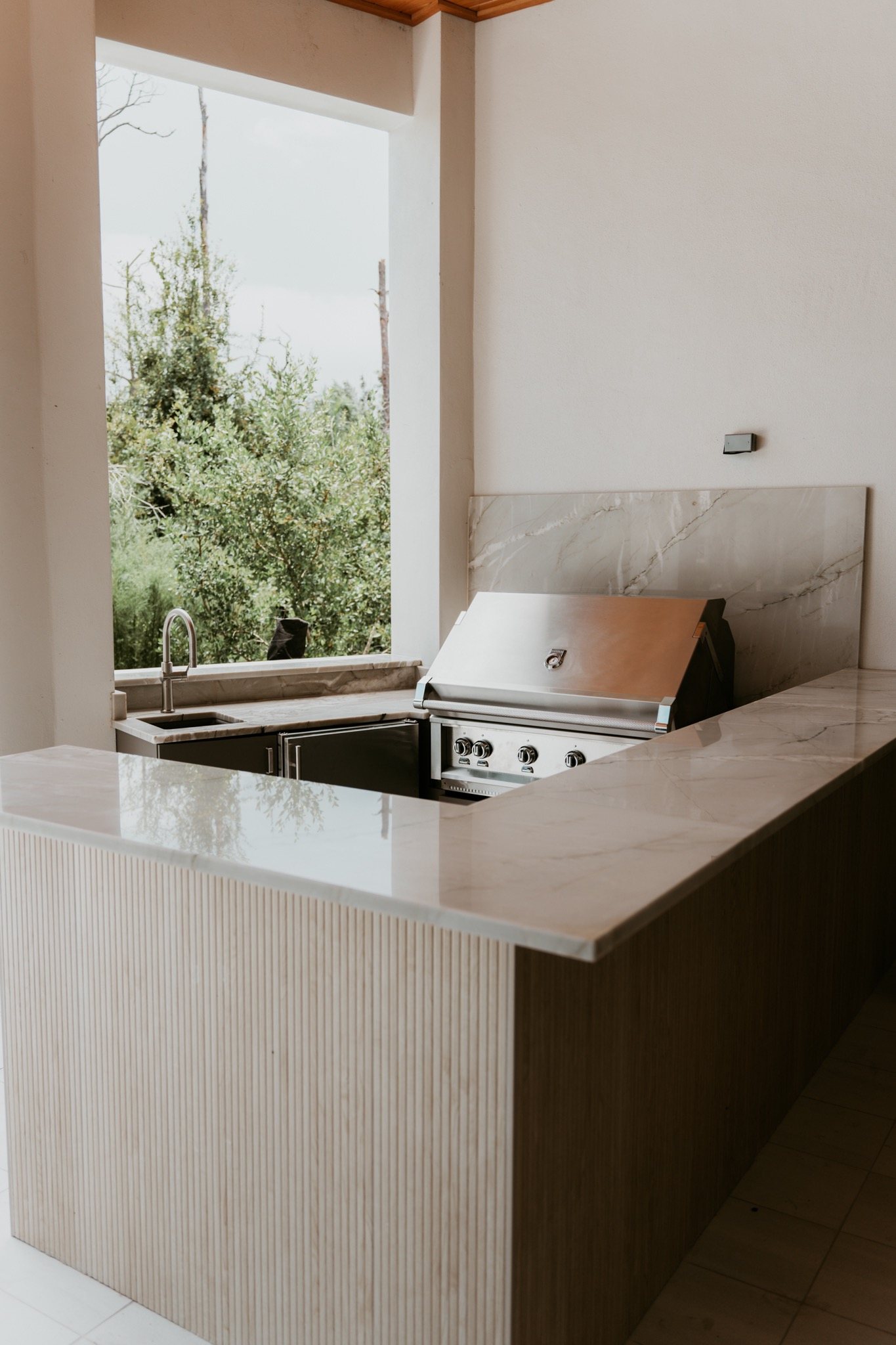 Outdoor grill counter with a stone top on a covered lanai